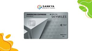 The image features an American Express Delta SkyMiles Business credit card with a sleek metallic design and geometric patterns. The card displays a chip, a contactless payment symbol, and the last four digits "7997," along with the text "Member Since 96." Above the card, the "Sankya Banking & Finance" logo is visible, incorporating a colorful arrow and bar chart icon. The background is white with abstract yellow, green, and orange shapes in the corners.