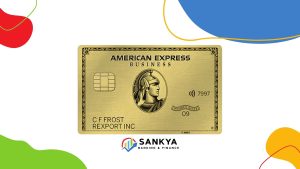 Illustrative image of the American Express Business Gold Card, showcasing its distinctive gold design tailored for business use, with a focus on the American Express logo, chip, and contactless payment symbol. The image also features colorful graphic elements and the Sankya Banking & Finance logo at the bottom.