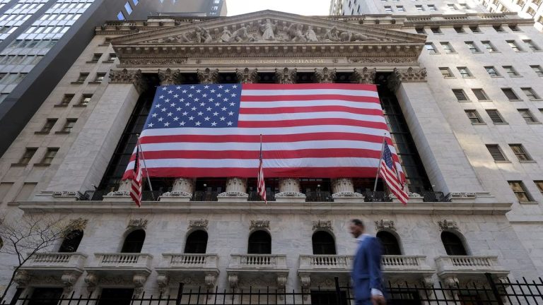 The New York Stock Exchange building with a giant American flag covering its facade, symbolizing financial security and stability often associated with U.S. Treasury Bonds.